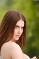 A woman with long brown hair and blue eyes posing for a picture.