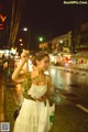 A woman in a white dress holding a bunch of flowers.