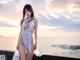 A woman in a white bathing suit standing on a pier.