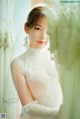 A woman in a wedding dress looking out a window.