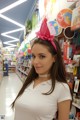 A woman in a white shirt is standing in a store.