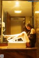 A woman sitting on a counter in front of a mirror.