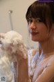 A woman is taking a bath with foam on her face.