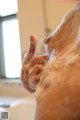 A close up of a person's hand in a bathtub with foam.