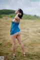 A woman in a blue dress standing in a field.