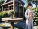 A woman in a kimono standing next to a table with flowers.