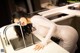 A woman in a white dress is washing her hands in a kitchen sink.