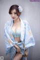 A woman in a blue and white kimono posing for a picture.