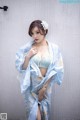 A woman in a blue and white kimono posing for a picture.