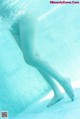 A woman's legs in the water of a swimming pool.