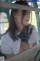 A woman in a white shirt and tie sitting on a bus.