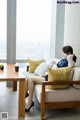 A woman sitting on a couch in a living room.