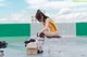 A woman sitting on top of a stool next to a box.