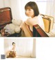 A woman sitting on top of a suitcase next to a teddy bear.