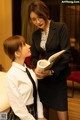 A woman in a business suit and a young girl in a school uniform.